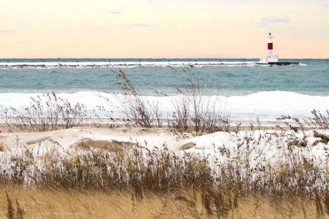 a beach in waukegan during the winter with snow on the sand