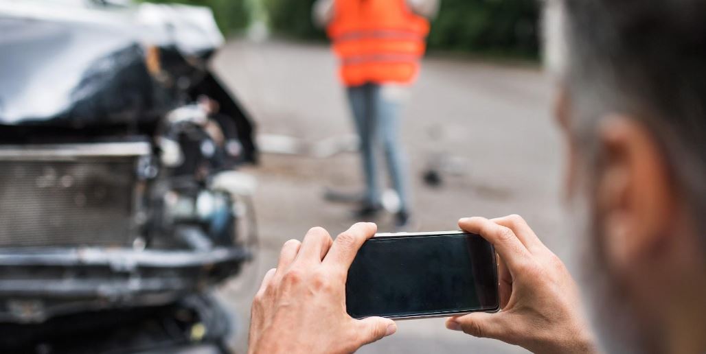 Man taks a picture of the car accident