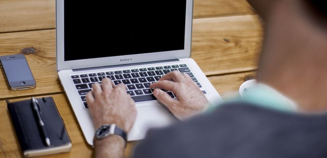 Man typing on his laptop