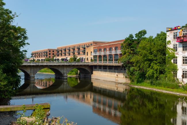 a riverside view of a bridge and buildings in aurora illinois